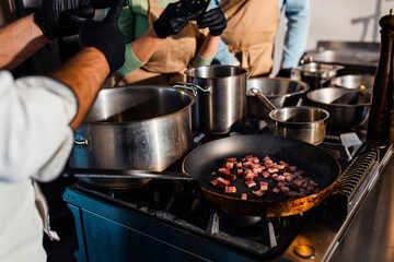 Close up of bacon in a frying pan in the kitchen.