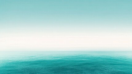 Fototapeta premium Serene seascape featuring a calm teal ocean under a pale, hazy sky. The image evokes a sense of tranquility and peace. Minimalist composition with