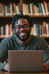 Smiling Man Working on Laptop in Library
