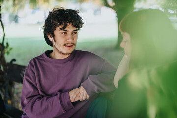 A young couple shares an intimate and peaceful moment in a serene outdoor setting. The natural surroundings and gentle expressions convey warmth and connection.