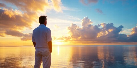 Fototapeta premium A man stands on the beach looking out at the ocean