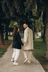 Fototapeta premium a love story of a stylish couple of hipsters dressed in casual clothes who have fun together on a walk , selective focus, noise effect