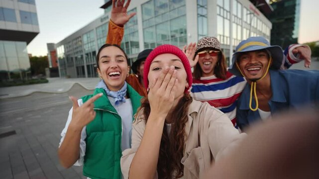 Trendy influencer friends taking selfie and doing online video call with mobile phone app in the city 
