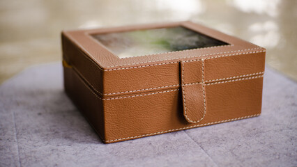 Brown leather jewelry box with glossy glass lid