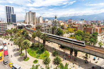 Medellin skyline with Metro de Medellín train at Plaza Botero in Medellin, Colombia