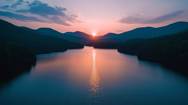 As the sun dips below the horizon, vivid hues dance across the serene surface of the lake, surrounded by majestic mountains that capture the last light of the day