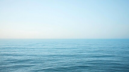 Obraz premium Calm Ocean Water Under A Pale Blue Sky