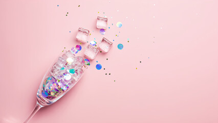 Fototapeta premium Crystal champagne cocktail glass filled with multicolor holographic confetti and ice on soft pink background. Concept of banner for Girl's Summer party or New Year event. Wallpaper with copy space