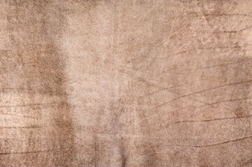 Light brown natural suede background with scuffs and creases.