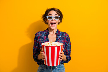 Photo of ecstatic woman dressed plaid shirt in 3d glasses hold popcorn staring at awesome movie...
