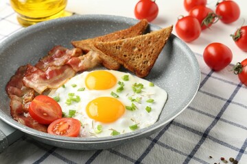 Tasty fried eggs with bacon and toasts served on table, closeup
