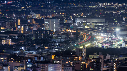 Lights from train and Kyoto Station in dense city at night