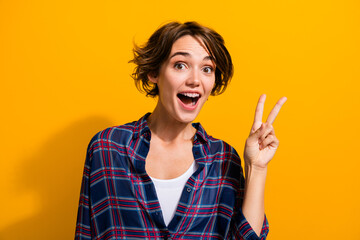 Photo of optimistic girlish woman with bob hairdo dressed checkered shirt showing v-sign say hi...