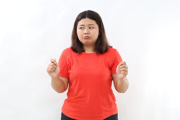 Thoughtful asian woman standing holding something while looking at upper right corner. Isolated on white