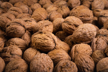 dried walnuts in their shells fill the frame completely. side angle view with selective focus. healthy food photo