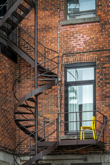 Rusty metallic outside spiral stairs on a brick building in Montreal, Canada