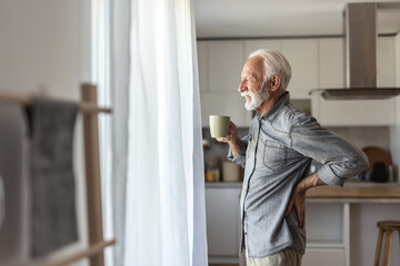 Fototapeta premium Senior men, back and injury with pain for bad posture, muscle tension or herniated disc at home. Close up, hands and pressure with sore spine, cramp or ache for fibromyalgia or discomfort at house.