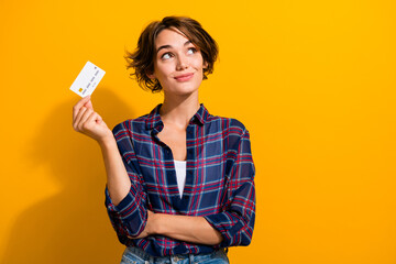 Photo of dreamy clever woman dressed checkered shirt hold credit card look at offer empty space...
