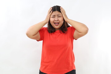 Shock, stress.Asian woman holding hands on head, posing against white background. Overworking,...