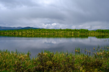 Sunset panorama of small lake with mountain reflection in Siberia, Buryatia, Russia