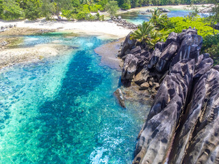 Aerial view of a tropical beach with granite rocks and turquoise water