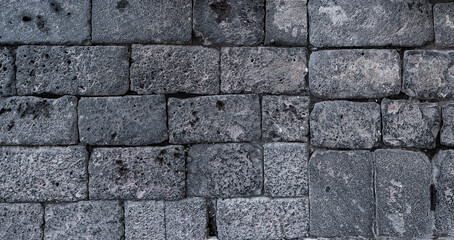 Rough textured volcanic stone wall, gray in color