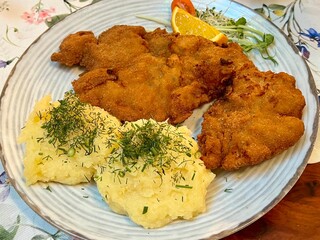 Polish traditional cuisine: kotlet schabowy, a crispy pork schnitzel served with mashed potatoes. Ideal for food-related projects, cultural themes, and showcasing classic Polish dishes.