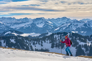 active senior woman  in winter on the Nagelfluh mountain chain near Oberstaufen, Bavaria, Germany