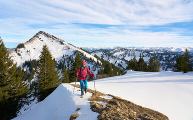 active senior woman  in winter on the Nagelfluh mountain chain near Oberstaufen, Bavaria, Germany