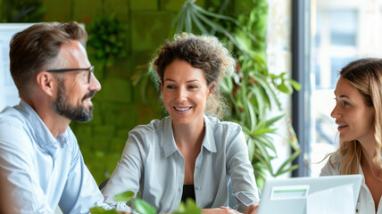 Group of diverse professionals engaging in a productive discussion in an eco-friendly office with green plants, focusing on innovation, strategy, and teamwork, Professionals Collaborating