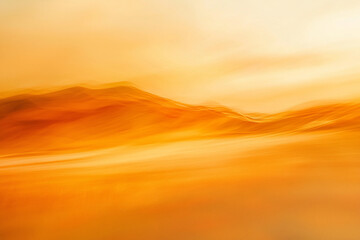 Obraz premium Abstract landscape featuring warm golden hues and blurred hills under a soft, glowing sky