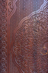 brown carved wooden door with intricate traditional uzbek patterns, east asian texture background