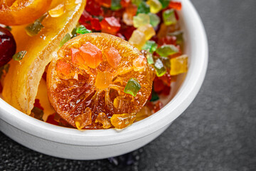 Candied peel and fruit orange, kumquat, tangerine, cherry, mango and others Sugar-coated fruit fresh tasty food dish delicious gourmet food background on the table rustic food top view copy space