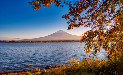 Mt. Fuji over Lake Kawaguchiko with autumn foliage at sunset in Fujikawaguchiko, Japan.