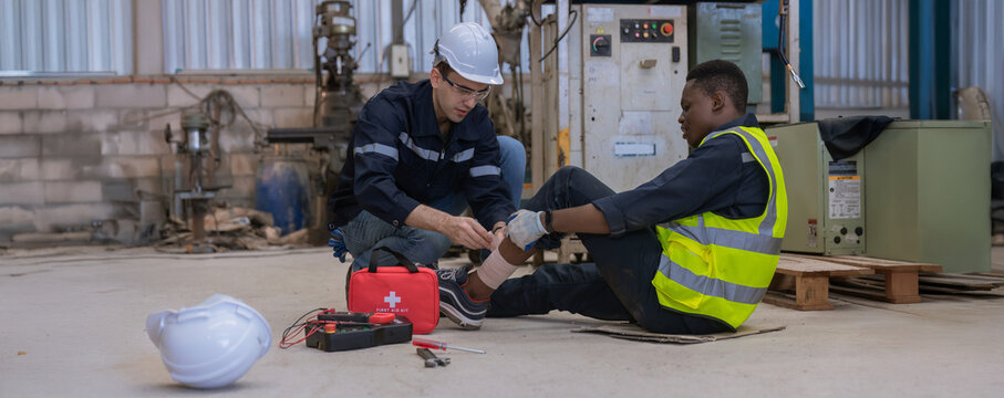 First aid support accident at work of worker at factory. Male worker has an accident on the floor in warehouse site.