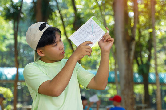 The boys used a clinometer to measure angles to calculate the height of the trees and calculate the trees' carbon storage.