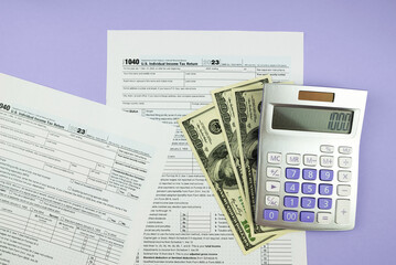1040 tax form 2023 . Tax return forms 1040 with office supplies and dollar bills. Time to pay taxes.