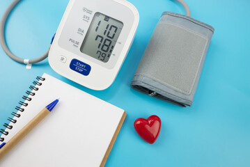 Red toy heart and tonometer on blue background. Healthcare concept. Cardiology - Heart care