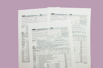 Fototapeta premium 1040 tax form 2024 . Tax return forms 1040 with office supplies and dollar bills. Time to pay taxes.