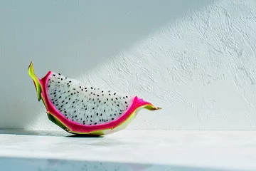 Rolgordijnen Freshly sliced dragon fruit resting on a marble surface with textured white wall in the background © Adi