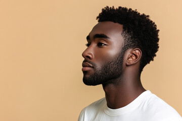 Obraz premium Professional studio portrait of a confident Black man in a white t-shirt with a modern hairstyle and groomed beard, ideal for fashion, lifestyle, and personal branding projects