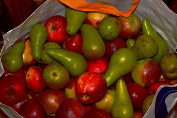 Realistic artificial plastic pears and apples in a bag.