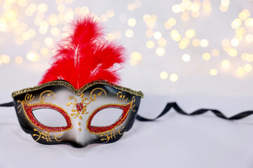 Beautiful carnival mask on color background, bokeh effect. Space for text