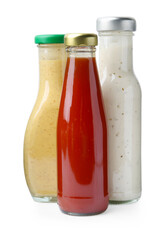 Different delicious sauces in glass bottles isolated on white
