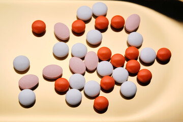 Colorful pills on a golden background.