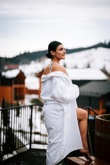 Woman in white swimsuit enjoys hot water in winter mountains with scenic backdrop