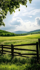 Vast green countryside field with a wooden fence under a bright sky  -