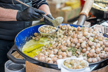 Masterful Chef Preparing Fresh Snails in a Bustling Market