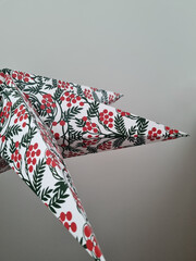Christmas paper star with a festive pattern. Festive background against the ceiling. Abstract background with a December holiday motive.