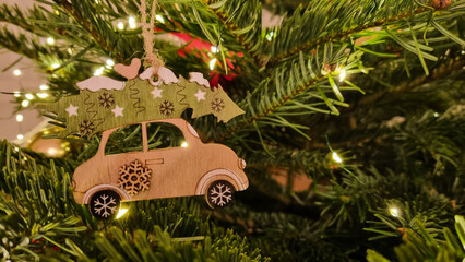 Christmas tree toy close-up. Christmas tree decoration and arrangement. LED lights and a wooden toy hanging on a branch.